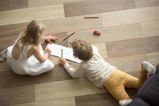 Kleine-Kinder-liegen-auf-Fussboden - Fußbodenheizungsverteiler einstellen